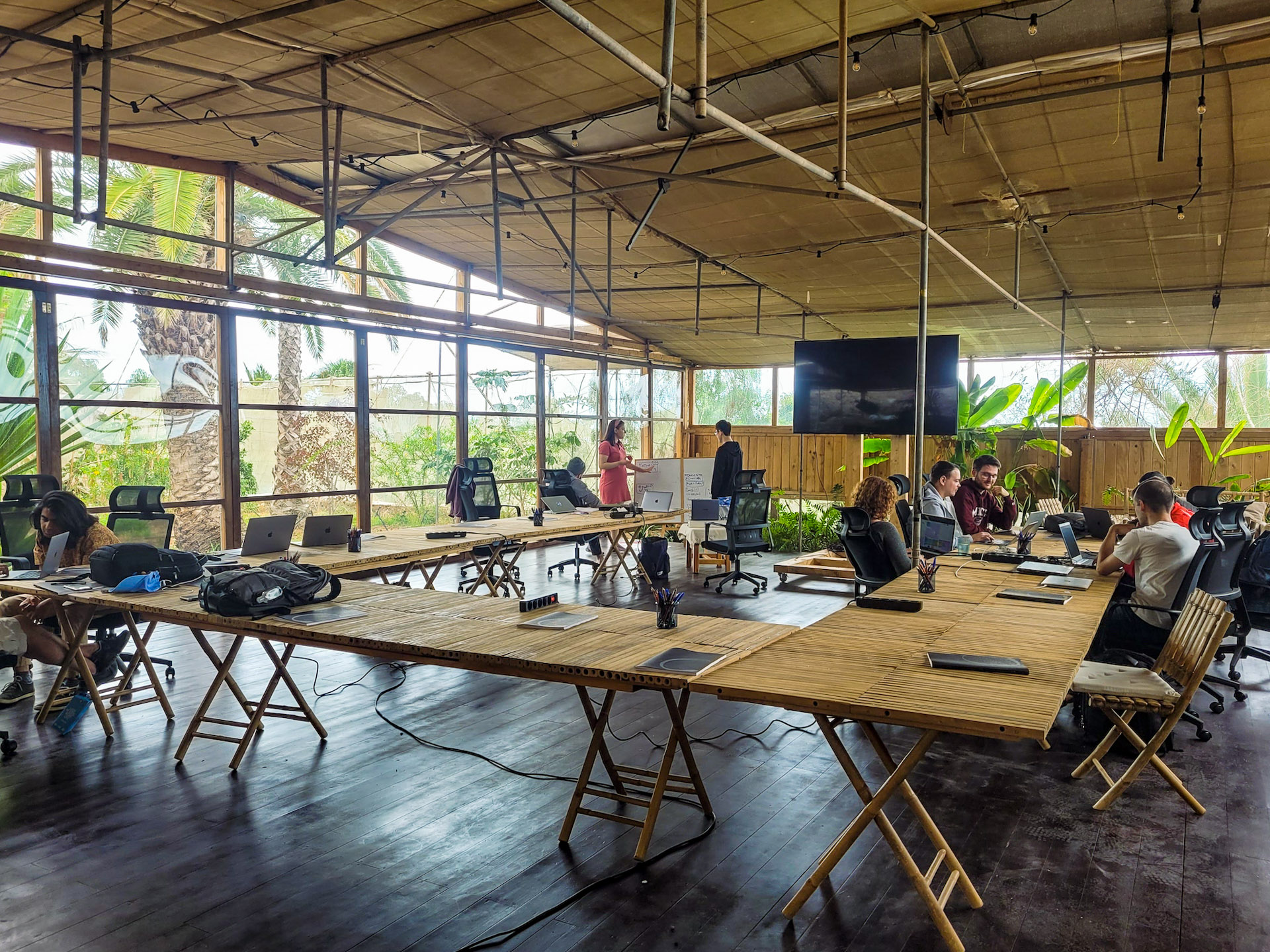 The product teams are seen spread out around a large indoor/outdoor workspace