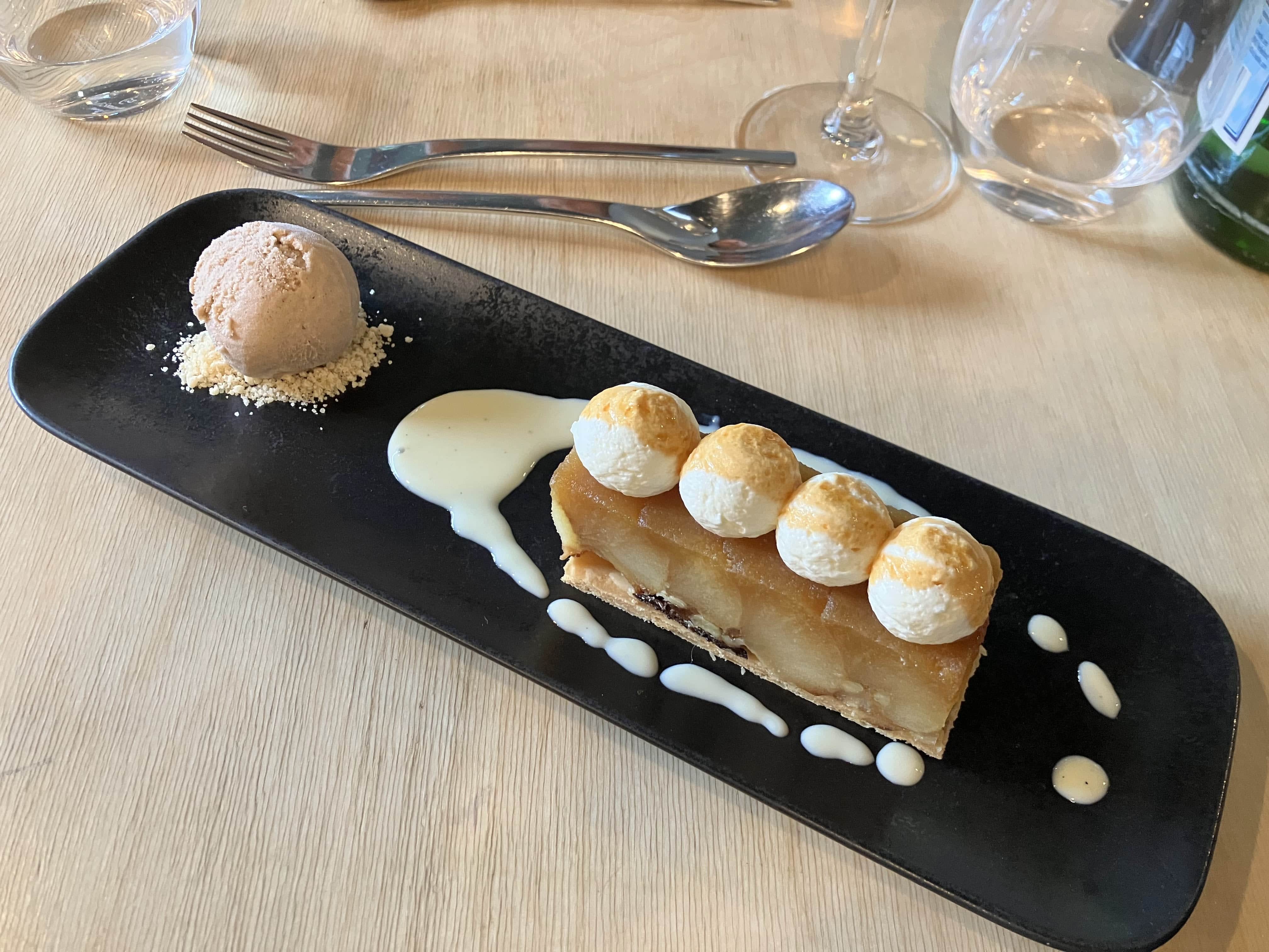 A plated apple dessert with three scoops of ice cream.