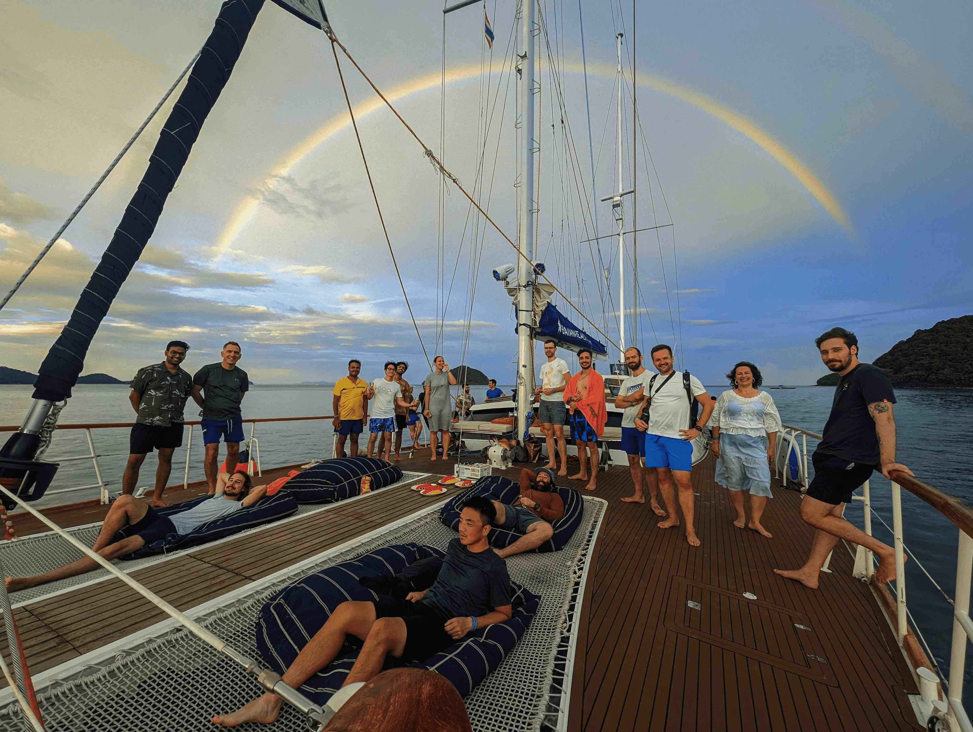 MUI team members enjoy a private catamaran trip. A rainbow appears over the team's boat.